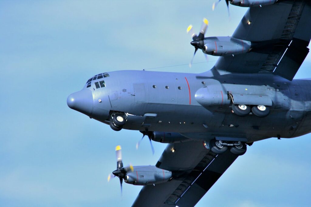 A close-up shot of a military aircraft with propellers in flight against a clear sky.